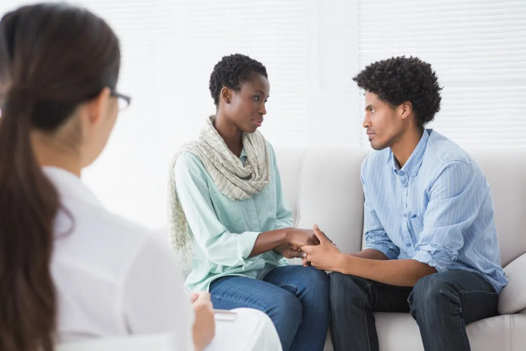 A couple holding hands during a counseling session